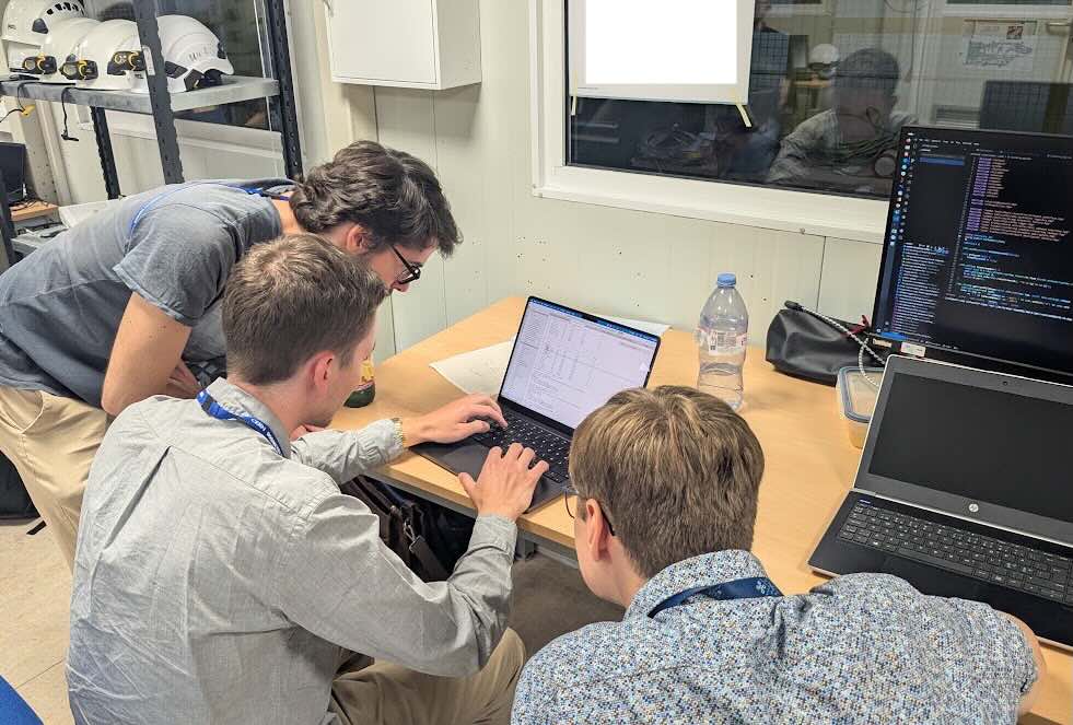 Debugging together, huddled around a laptop